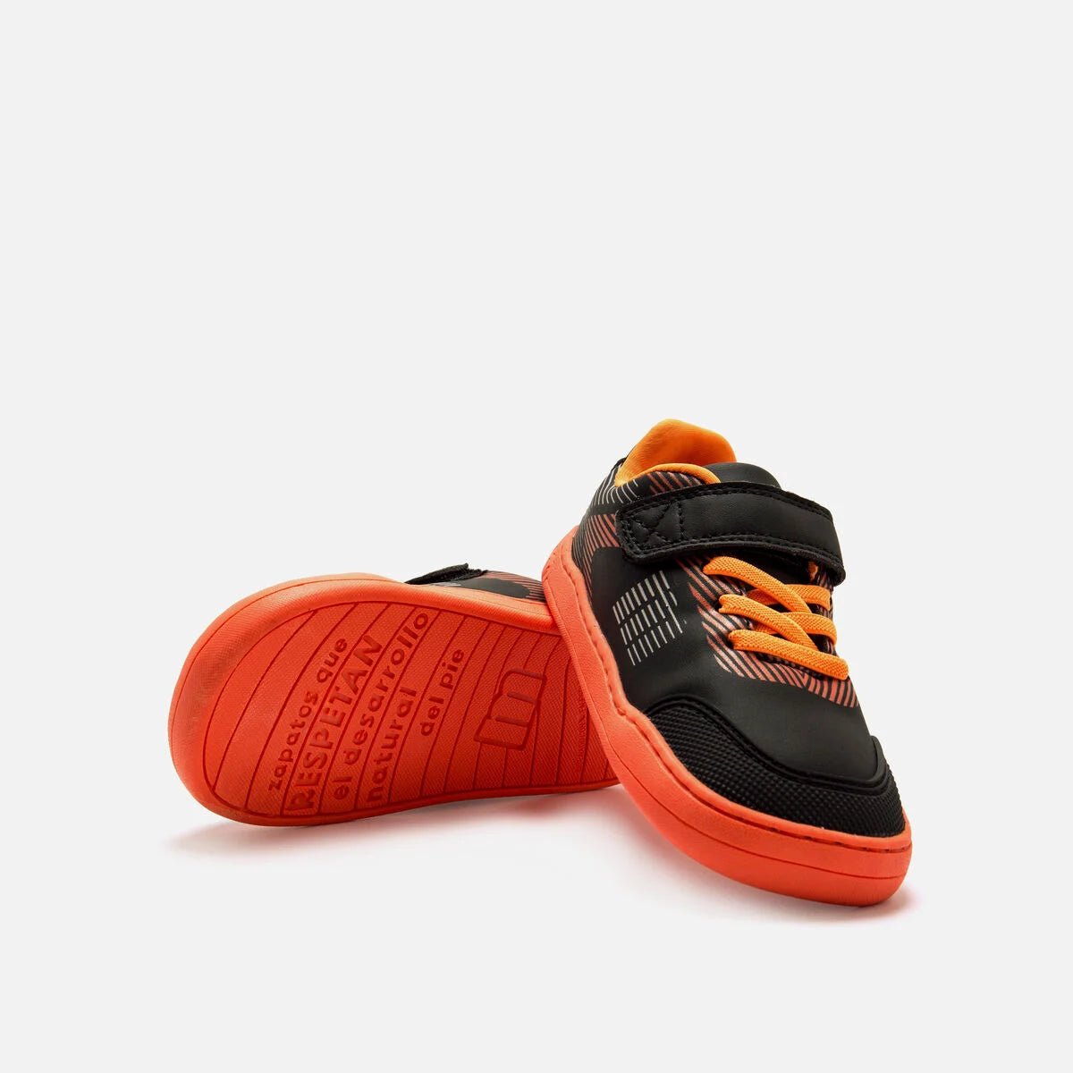 Mustang Free Multideporte infantil negra i taronja amb velcro, puntera reforçada i disseny barefoot esportiu.